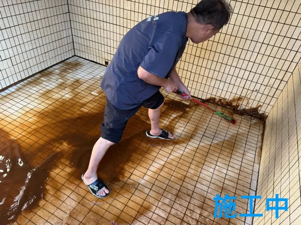 深美長照中心水塔清洗中人員刷洗磁磚底面與角落