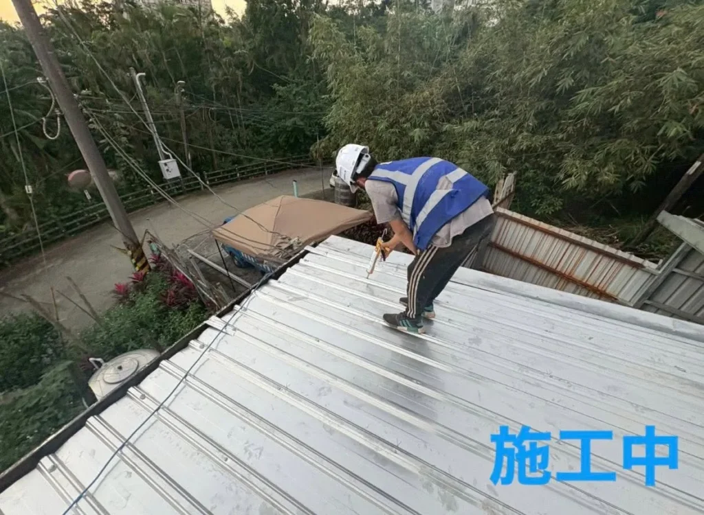 基隆明德二路施工人員鋪設並鎖固新鐵皮屋面板