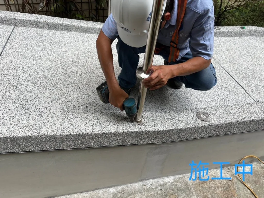 木柵白鐵欄杆施工中人員在步道地坪固定立柱