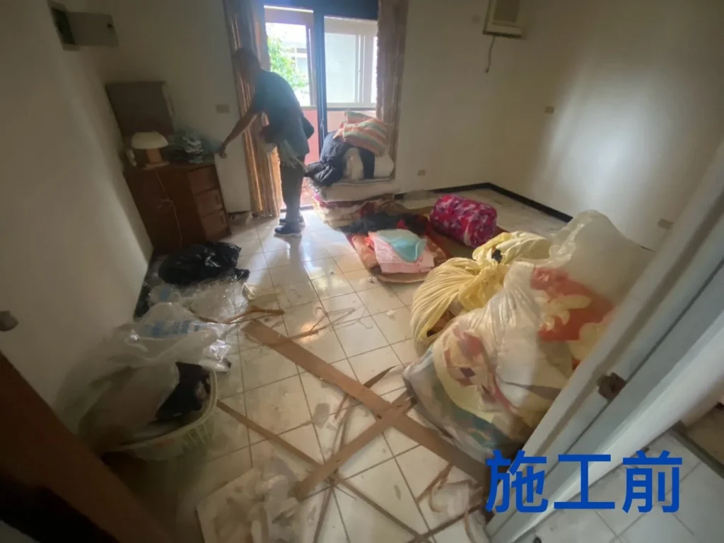 龍潭住宅清運前房間地面堆放寢具與袋裝物品