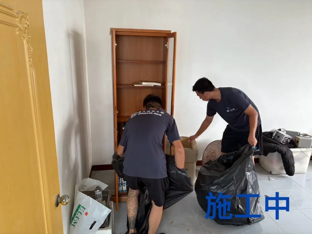龍潭住家清運中施工人員將櫥櫃周邊物品分類裝袋