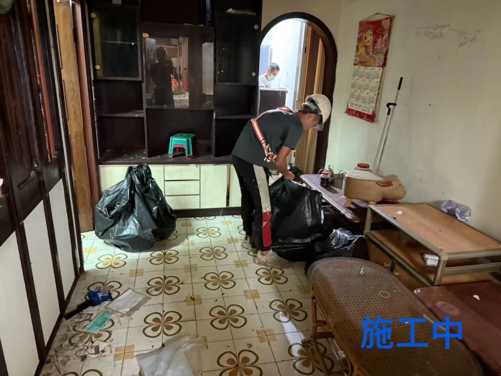 仁二路住家清運中人員將客廳零散物品分類裝袋