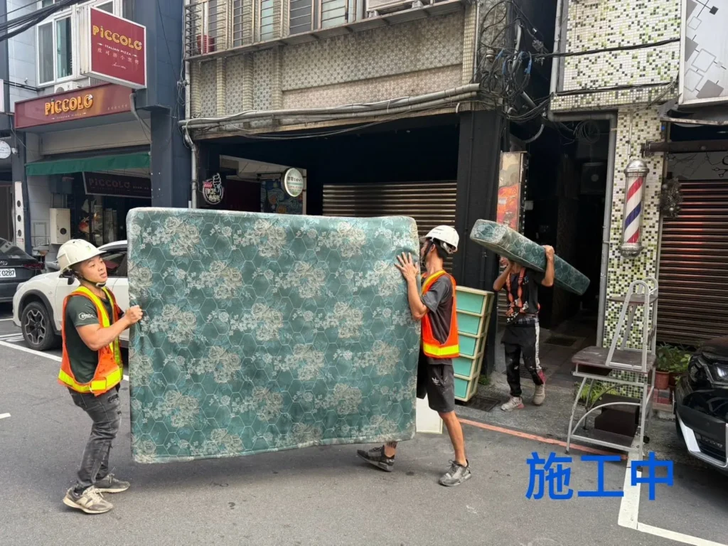 基隆廟口清運中施工人員於街道搬運床墊