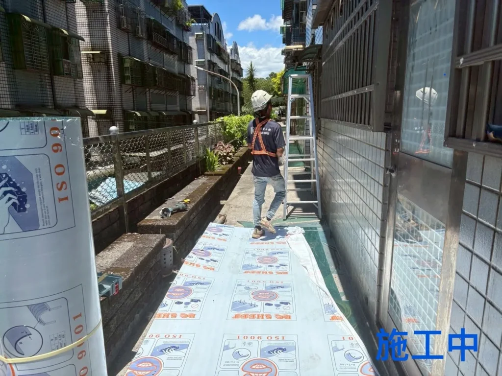 全民一家社區 PC 耐力板施工中,新板沿狹長雨遮框架範圍鋪設