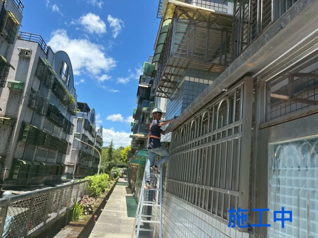 全民一家社區 PC 雨遮施工中,施工人員使用梯具進行外側安裝