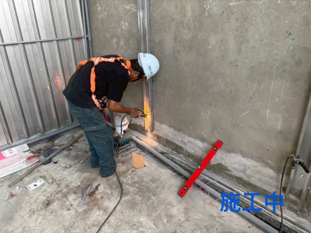 中壢松江北路曬衣架施工中,施工人員裁切金屬桿件準備安裝