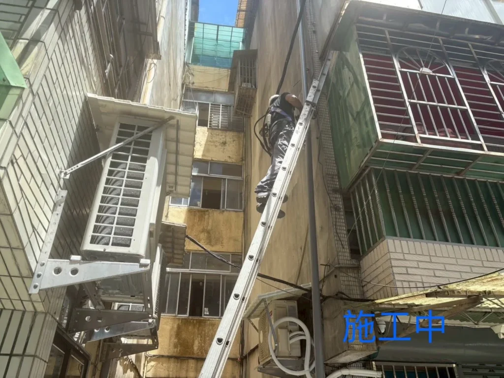 中平街洩水管施工中,梯具架設於狹巷並配合外牆管路安裝