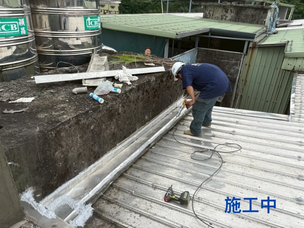 基隆新西街鐵皮屋補強施工中,施工人員處理屋頂邊緣防漏水