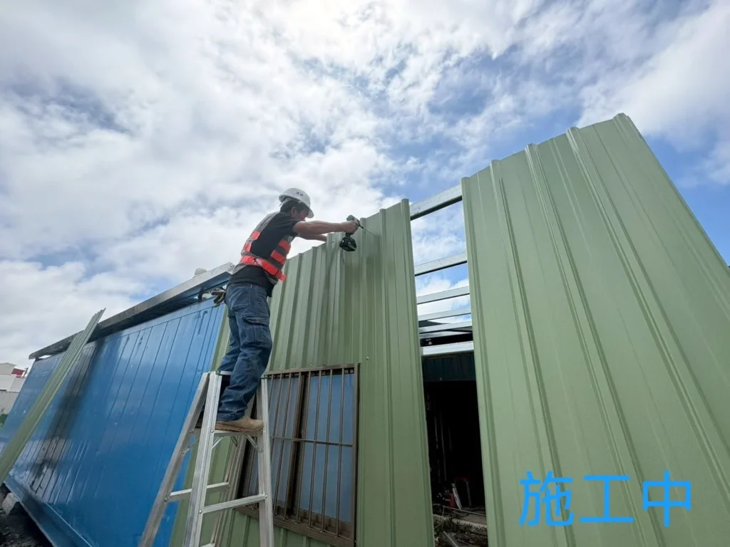 蘆竹鐵皮屋施工中,施工人員安裝綠色烤漆浪板壁面