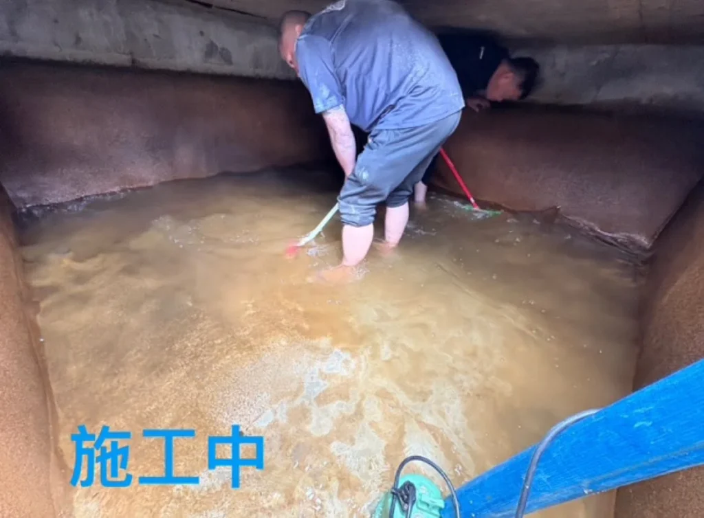 明德二路水塔清洗施工中,人員刷洗並沖除混濁污水