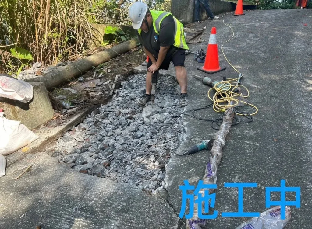 銘傳國中車道施工中,人員鑿除鬆動路面並清出碎料