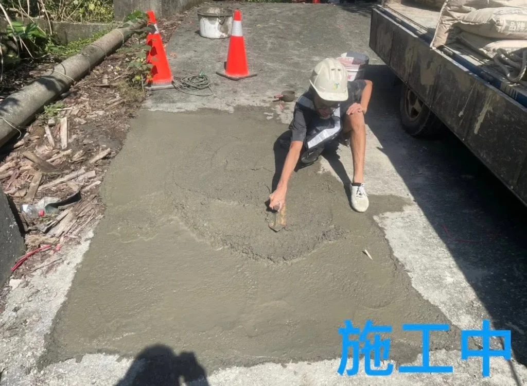 銘傳國中車道坑洞施工中,人員將修補材料填入並抹平