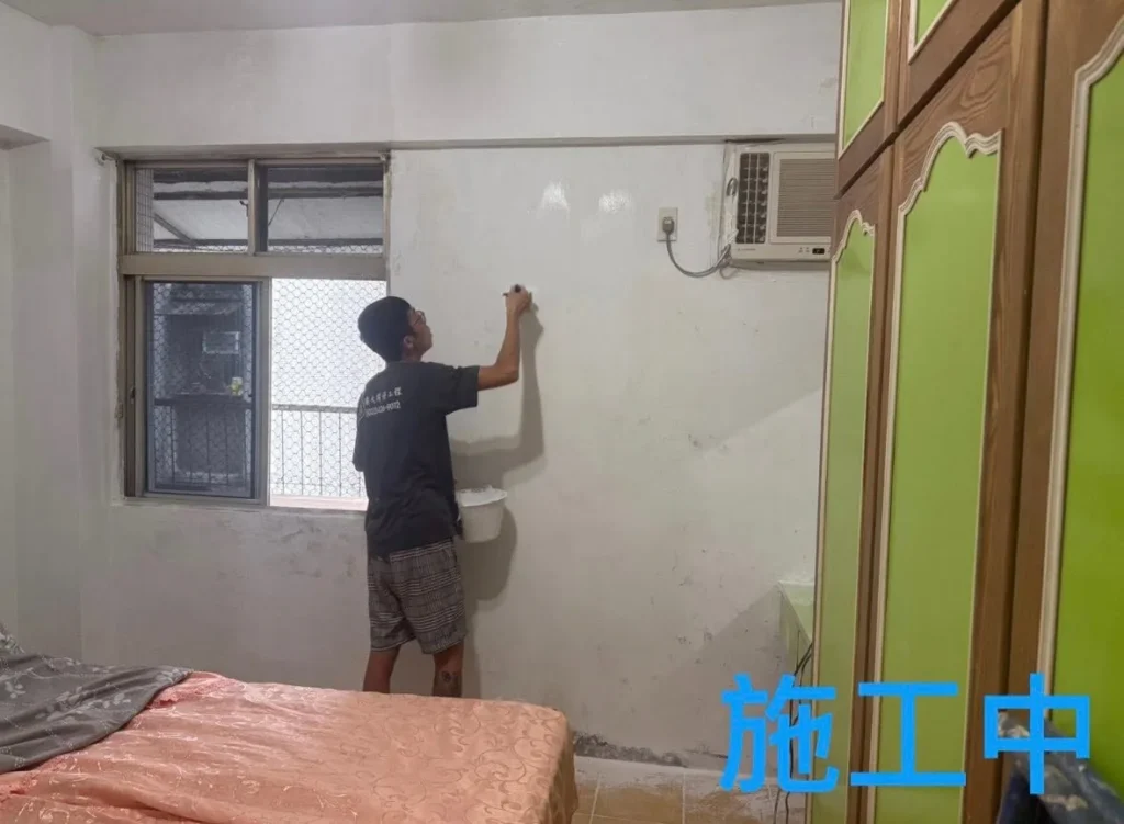 自來街牆面油漆施工中,人員整理窗旁壁面基層