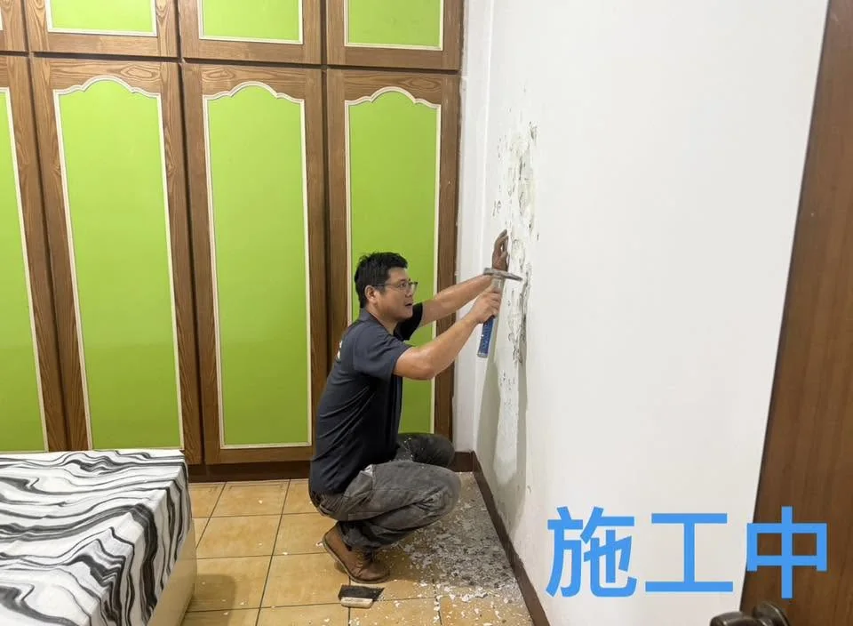自來街牆面修繕施工中,人員鏟除櫃體旁鬆動舊漆