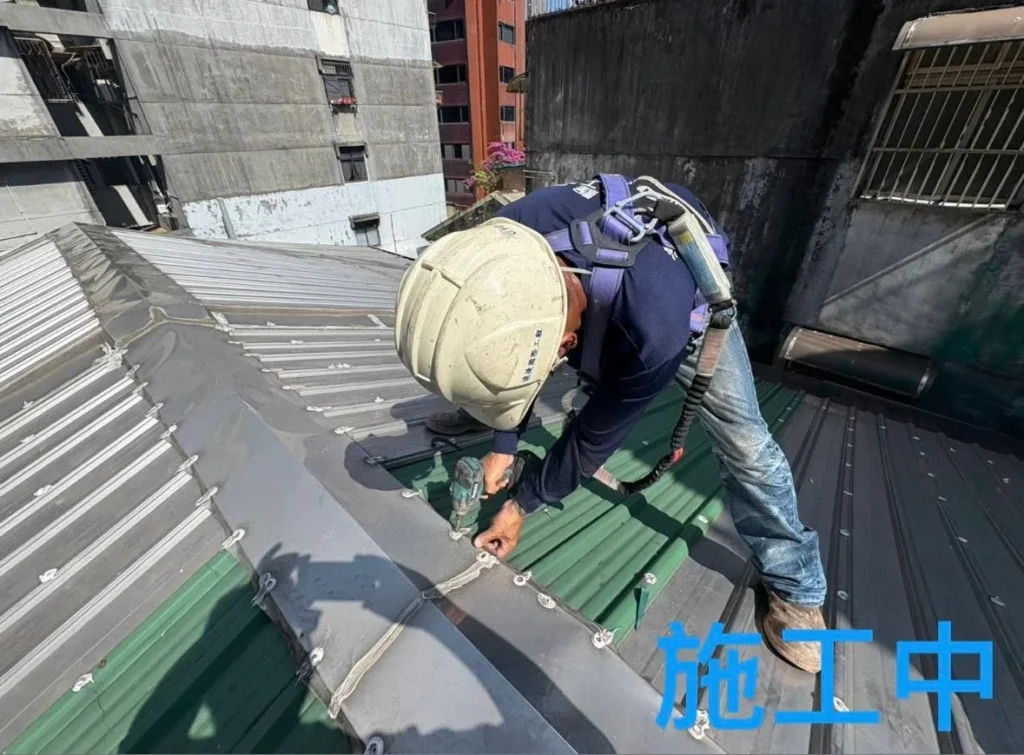 基隆崇安街屋頂換板施工中,人員施作屋脊與板材搭接收整