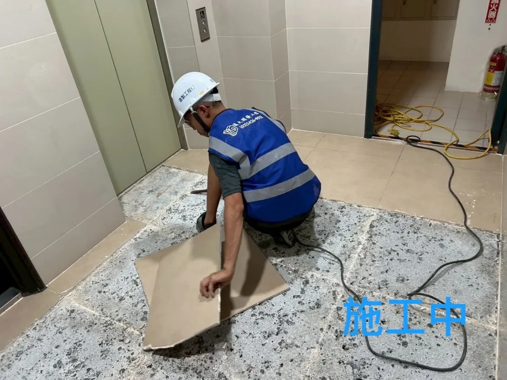 普羅旺世社區電梯口施工中,人員搬移地坪舊磁磚並清理底層