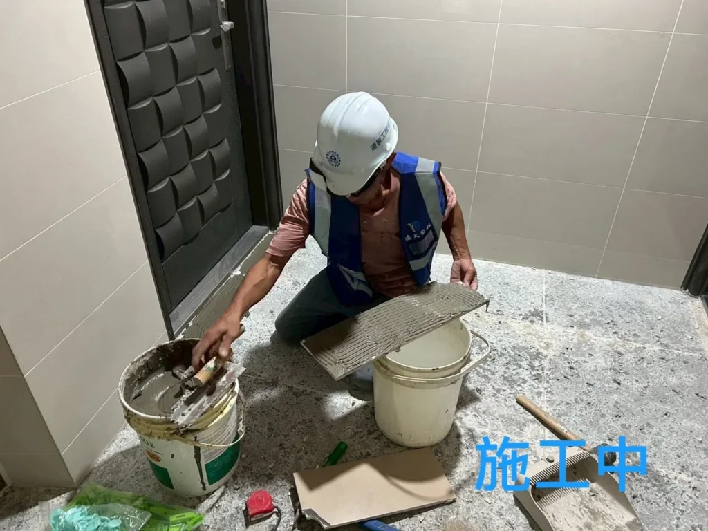 社區地坪磁磚施工中,人員拌製與塗抹貼磚用泥作材料