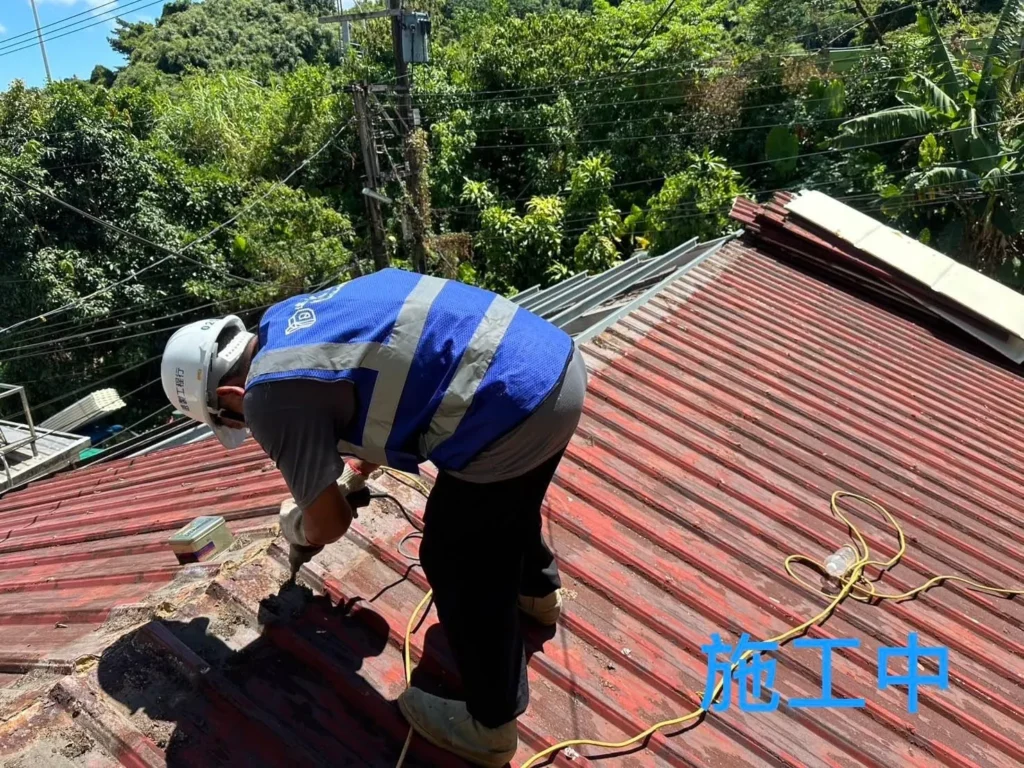 獅球路鐵皮屋頂施工中,人員拆除舊屋脊與板材固定件