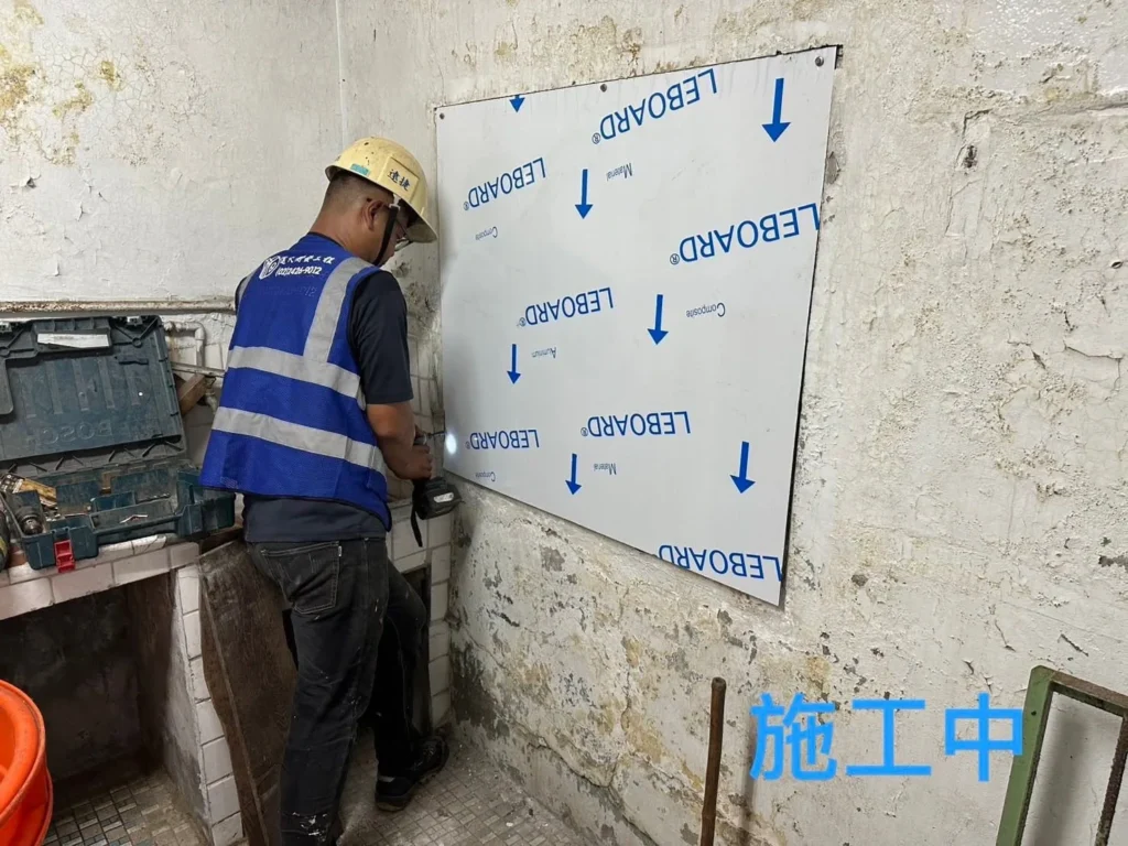 基隆獅球路窗框封板施工中,人員定位帶有保護膜的新板材
