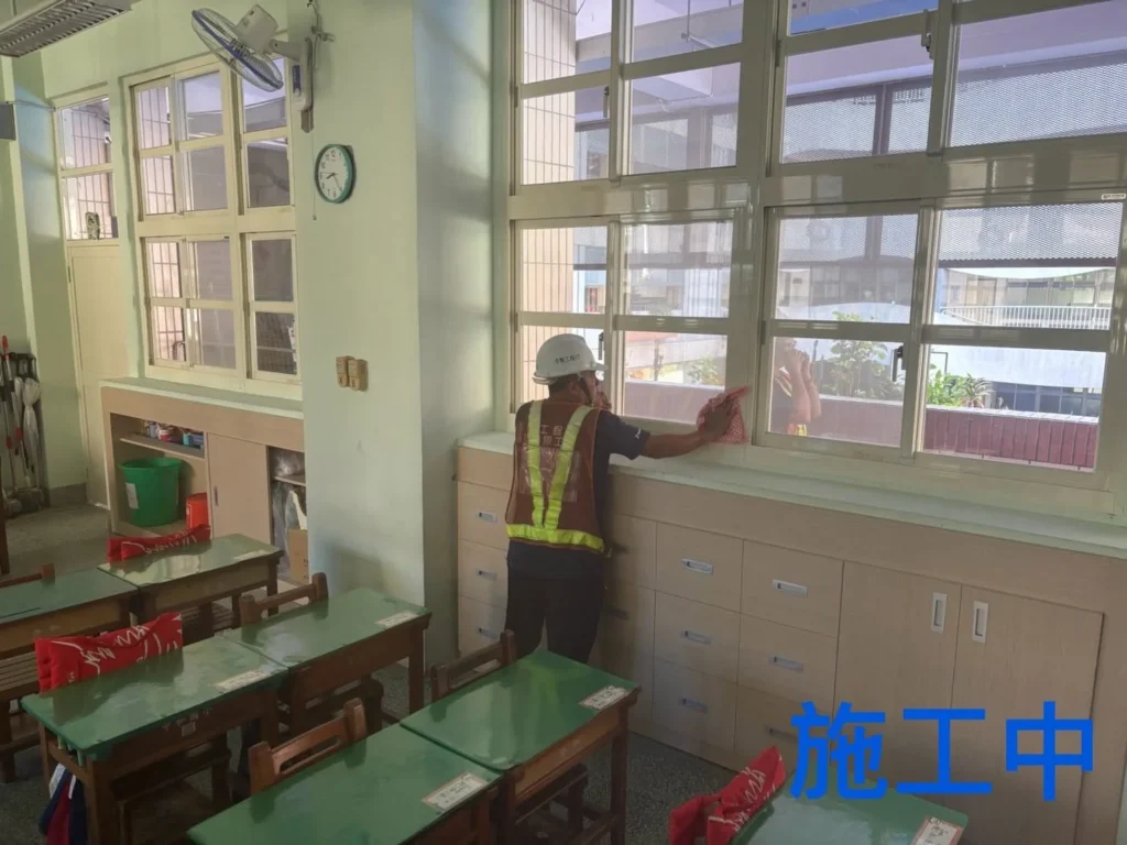 基隆中和國小清潔施工中,人員擦拭教室窗台