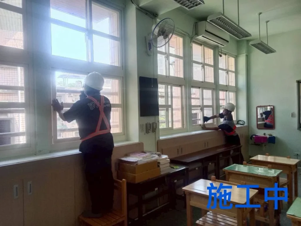 基隆中和國小窗戶清潔中,兩名人員分工擦拭玻璃