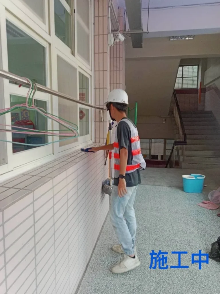 中和國小走廊清潔中,人員處理窗台與牆面周邊