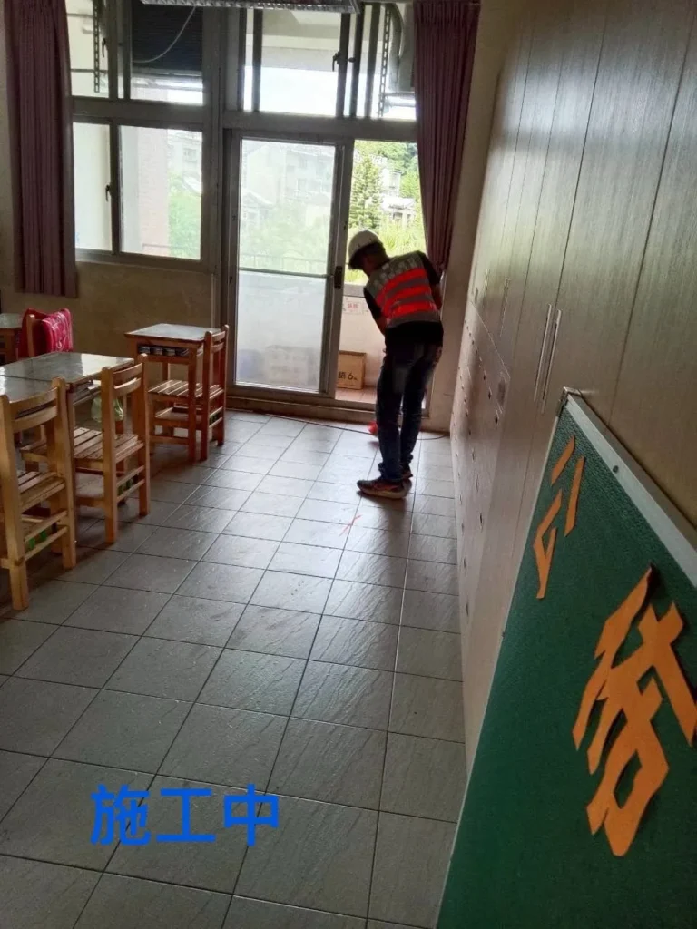 基隆中和國小教室清潔中,人員處理講台旁地面