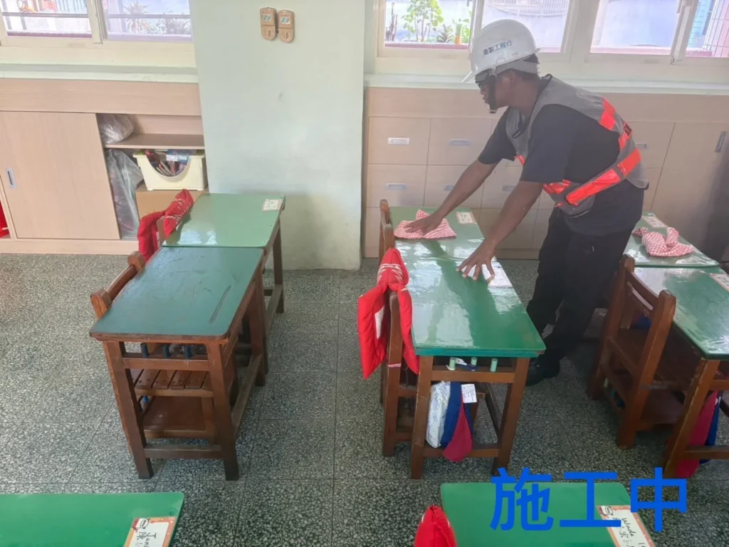 中和國小清潔施工中,人員逐張擦拭綠色課桌