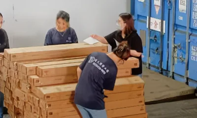 物流人員在貨櫃旁清點並整理堆疊木箱