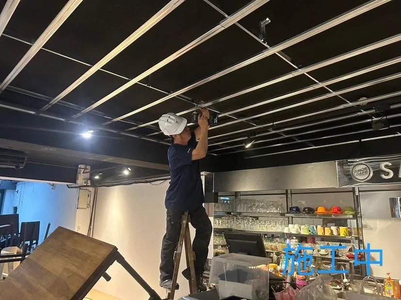 台北中山區暗架天花施工中,作業人員站在梯具上固定金屬骨架