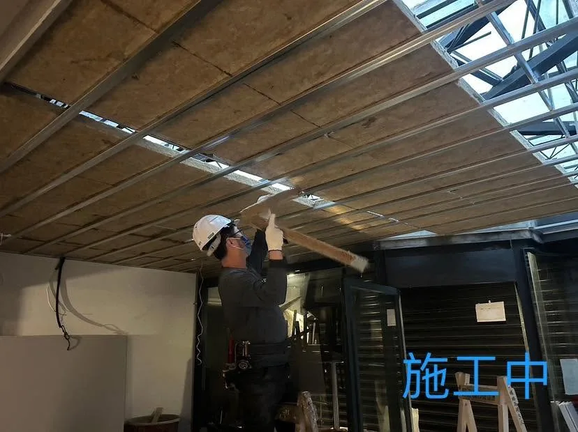 台北中山區暗架天花施工中,作業人員逐片安裝骨架內填充板材