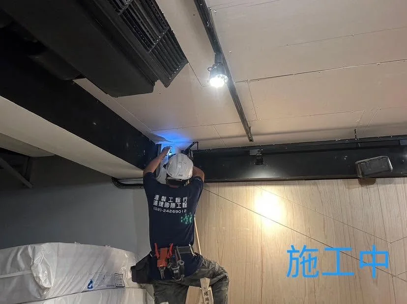 台北中山區暗架天花施工中,作業人員站在梯具上固定天花封板