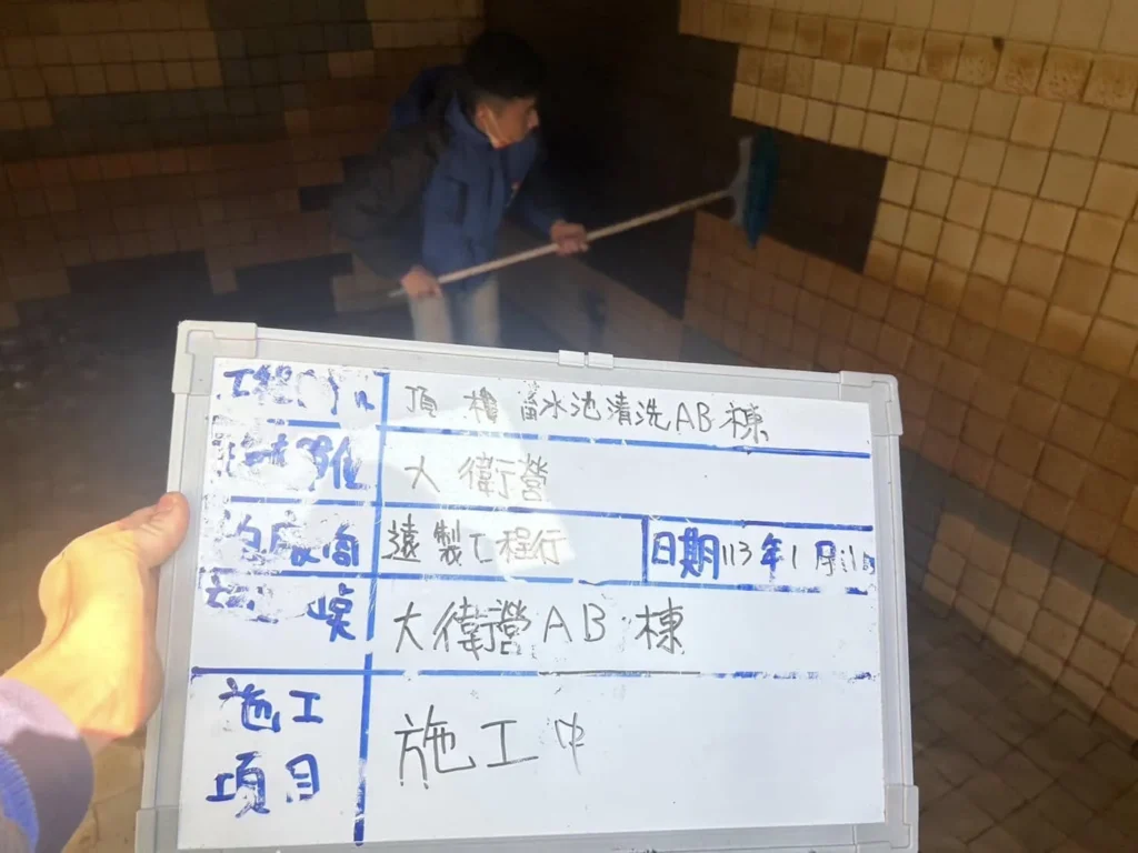 基隆安樂區大衛營社區水塔清洗施工中,作業人員刷洗頂樓蓄水池磁磚牆面
