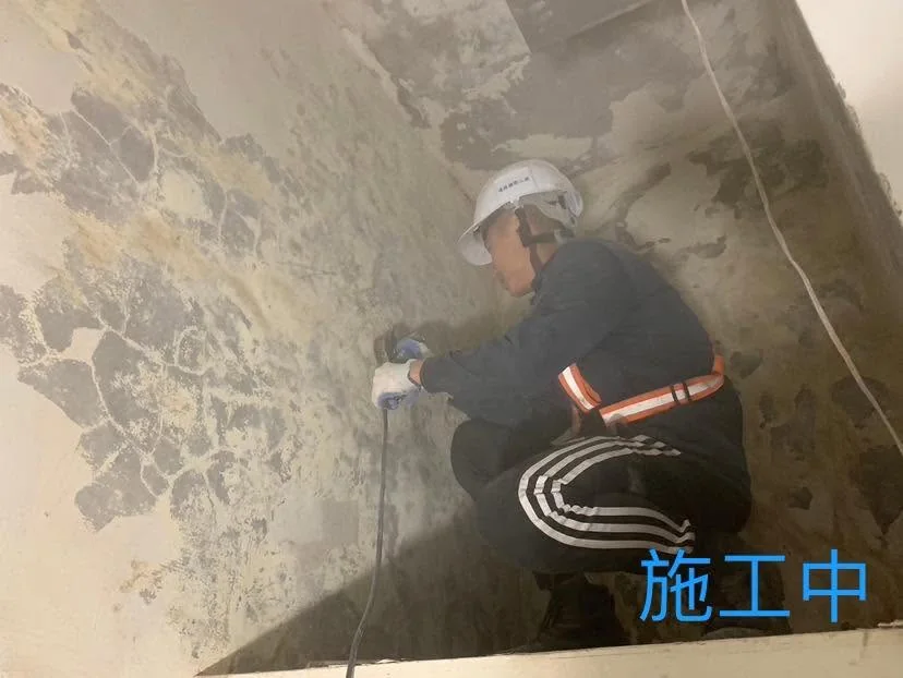 基隆仁愛區全室油漆施工中,作業人員使用電動工具打磨斑駁牆面