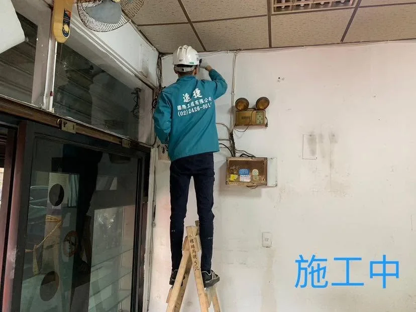 基隆仁愛區全室油漆施工中,作業人員在木梯上滾塗牆面高處