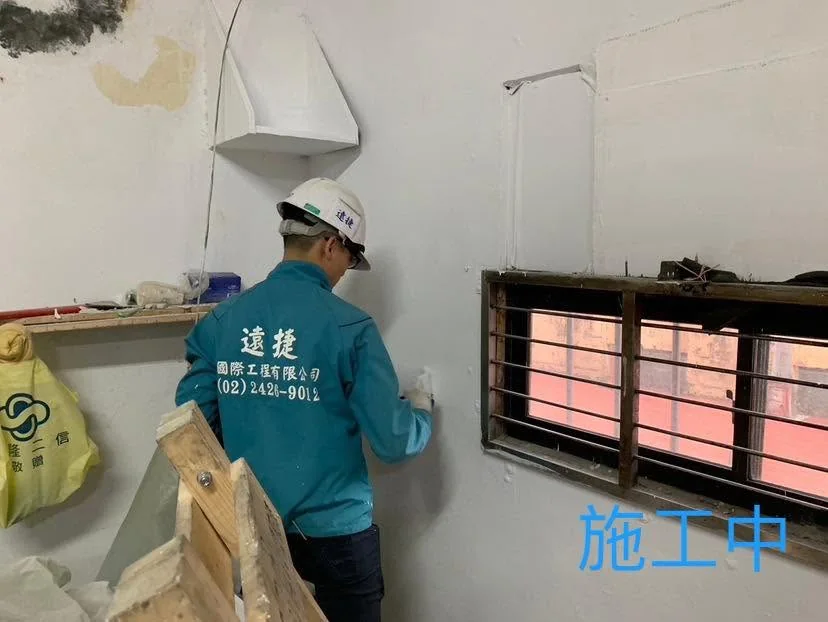 基隆仁愛區全室油漆施工中,作業人員滾塗窗戶周邊牆面