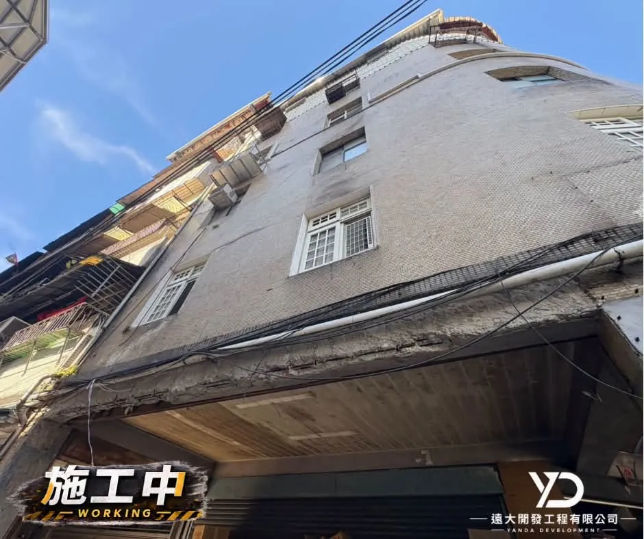 基隆市百五街老屋梁柱施工中,從街角仰視騎樓梁柱修繕範圍