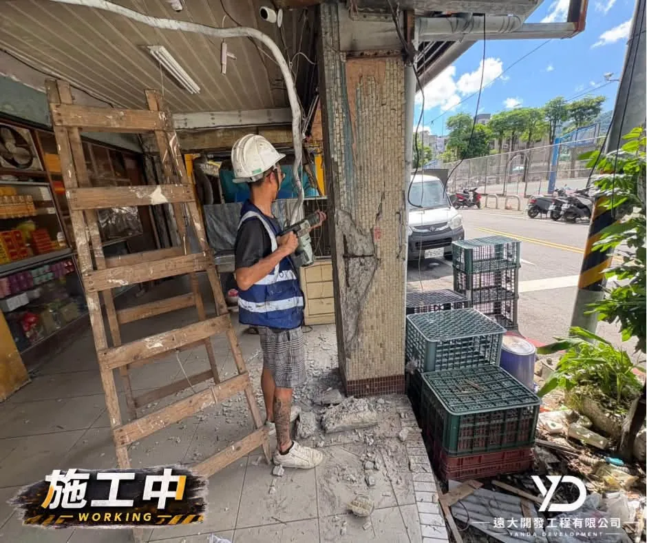 基隆市百五街柱面施工中,施工人員在街側持工具處理柱腳與柱