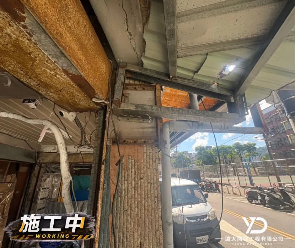 基隆市百五街梁柱施工中,鏽蝕的鐵捲門