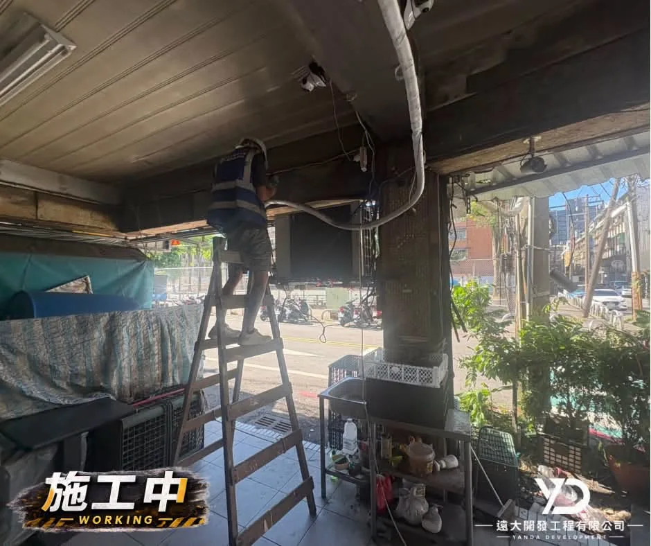 基隆市百五街梁底施工人員站在梯具上進行移除鐵捲門