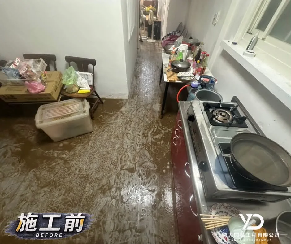 基隆市仁愛區災後清理施工前，廚房通道地面遍布泥水