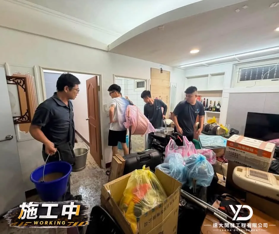 基隆市仁愛區災後清理施工中，多人整理裝袋物品並提桶清理室內